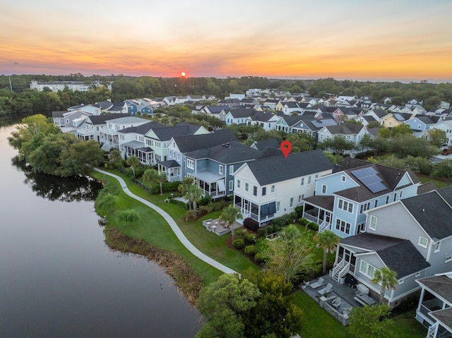 aerial view at dusk featuring a water view