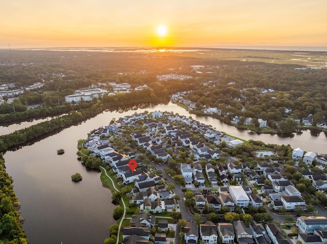 aerial view at dusk featuring a water view