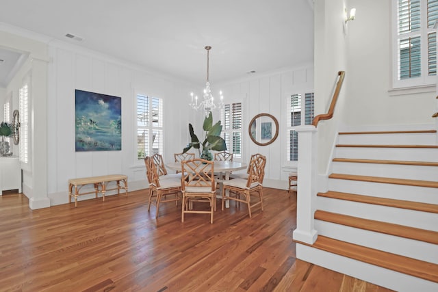 dining space featuring a chandelier, wood-type flooring, and ornamental molding