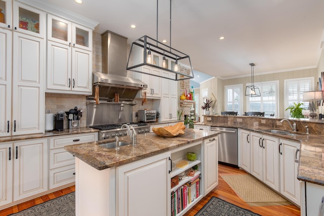 kitchen with stainless steel dishwasher, a sink, wall chimney range hood, ornamental molding, and decorative backsplash