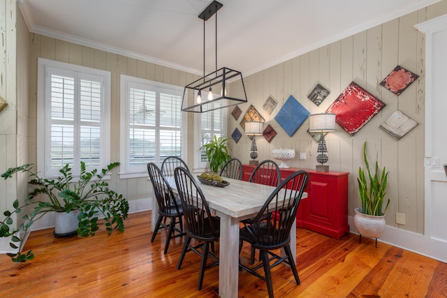 dining space featuring crown molding and light wood-type flooring