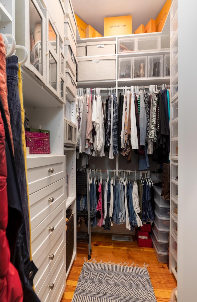 walk in closet with light wood-style flooring
