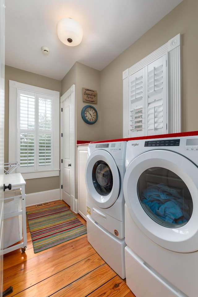 washroom with washer and clothes dryer, light wood finished floors, and baseboards