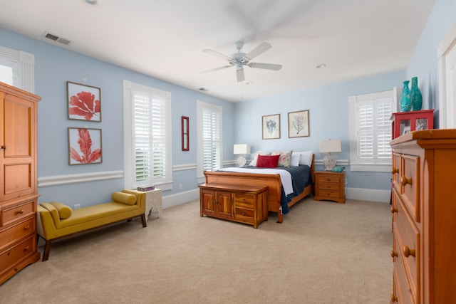 bedroom with light carpet, baseboards, and a ceiling fan