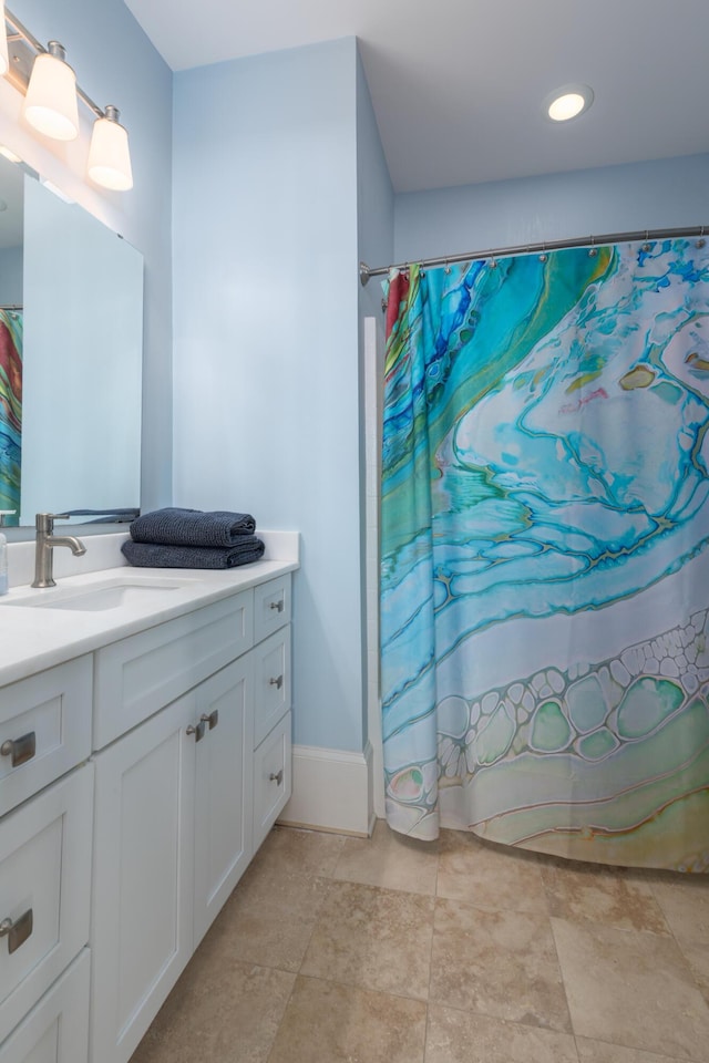 full bath with vanity, curtained shower, and baseboards