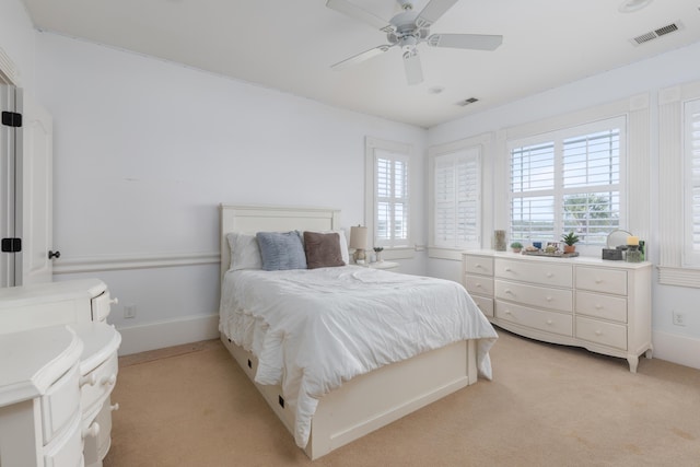 bedroom with light carpet, baseboards, and a ceiling fan