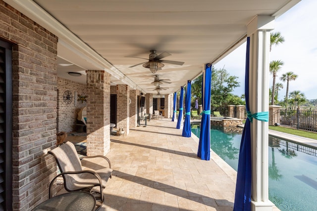 view of patio / terrace with a pool with connected hot tub, fence, and a ceiling fan