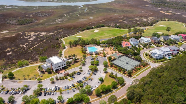 aerial view of property and surrounding area featuring a golf club and a large body of water
