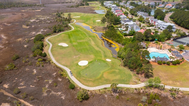 aerial overview of property's location with a golf club, a nearby body of water, a pool area, and nearby suburban area