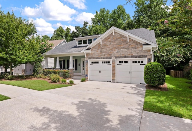 craftsman inspired home featuring a porch, a garage, and a front lawn