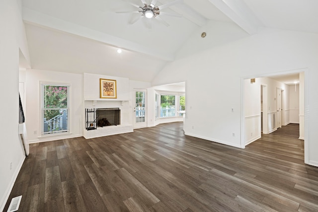 unfurnished living room with beamed ceiling, dark hardwood / wood-style flooring, a wealth of natural light, and a fireplace