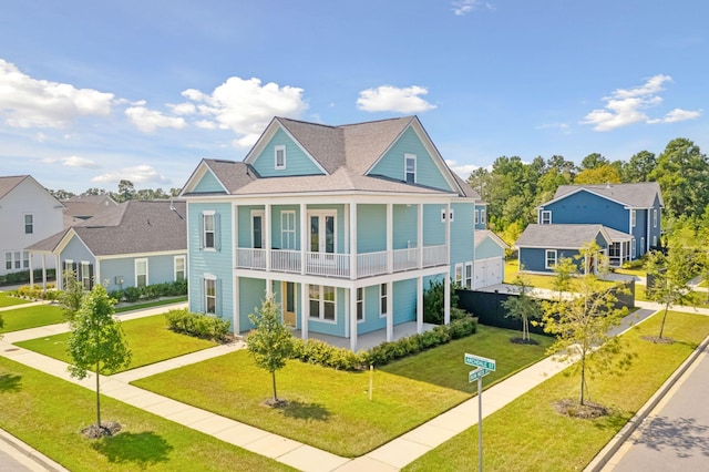 view of front facade with a balcony, covered porch, and a front yard