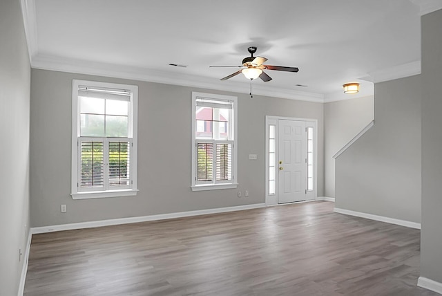 foyer with visible vents, baseboards, ornamental molding, wood finished floors, and a ceiling fan