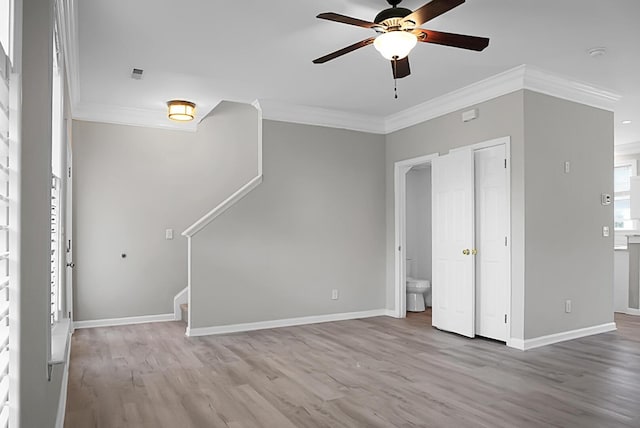 unfurnished living room with baseboards, wood finished floors, ceiling fan, and crown molding