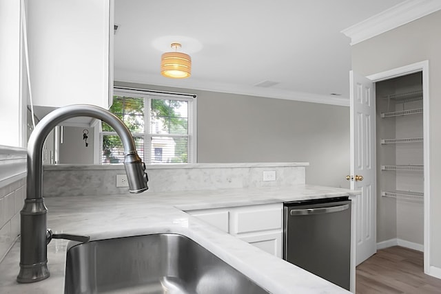 kitchen featuring a sink, crown molding, light stone counters, stainless steel dishwasher, and white cabinets