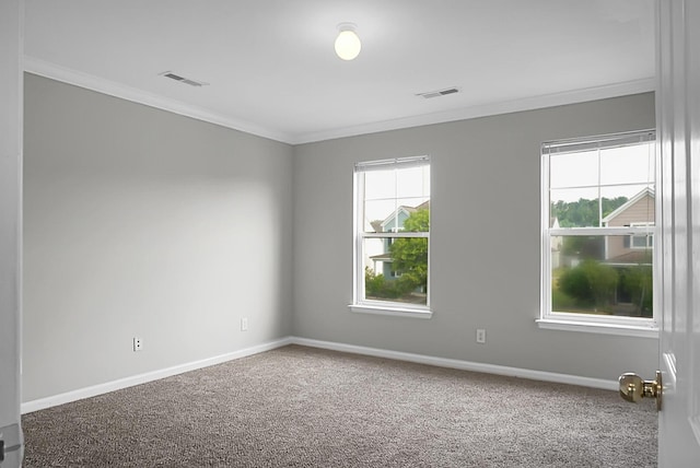 empty room featuring ornamental molding, visible vents, carpet floors, and baseboards