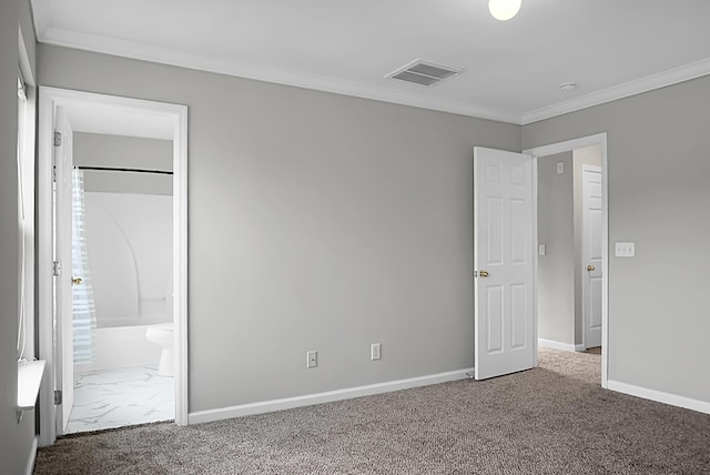 unfurnished bedroom featuring ensuite bath, carpet, ornamental molding, baseboards, and visible vents