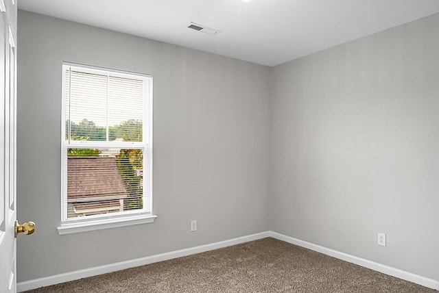 spare room with carpet, visible vents, and baseboards