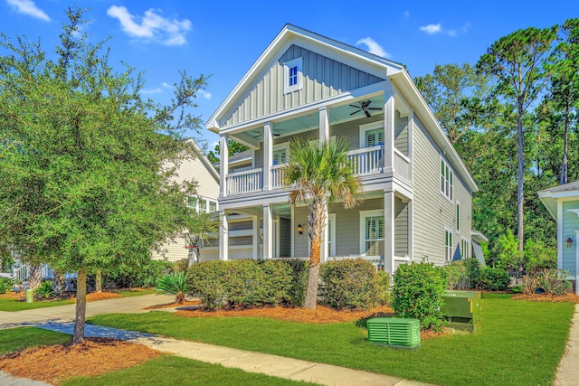 view of front of property featuring a front yard, a balcony, a porch, and ceiling fan