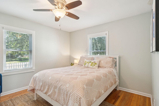 bedroom with wood finished floors, a ceiling fan, and baseboards