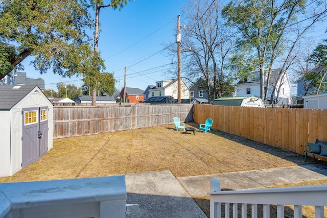 view of yard featuring an outbuilding, a fenced backyard, and a shed