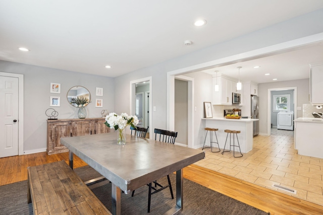 dining space featuring washer / dryer, visible vents, light wood-style floors, and recessed lighting