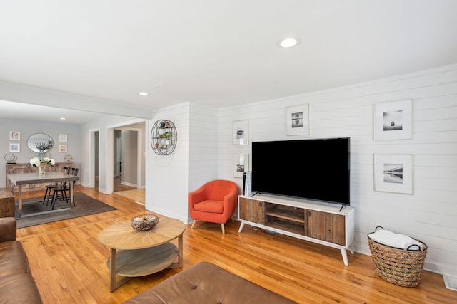 living room featuring light wood-type flooring, baseboards, and recessed lighting