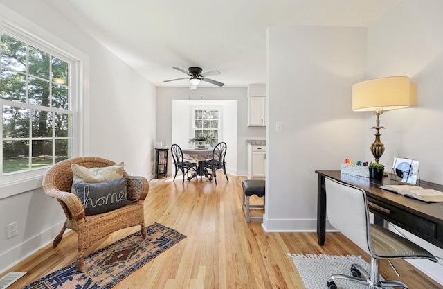 office area with ceiling fan, light wood-style floors, visible vents, and baseboards