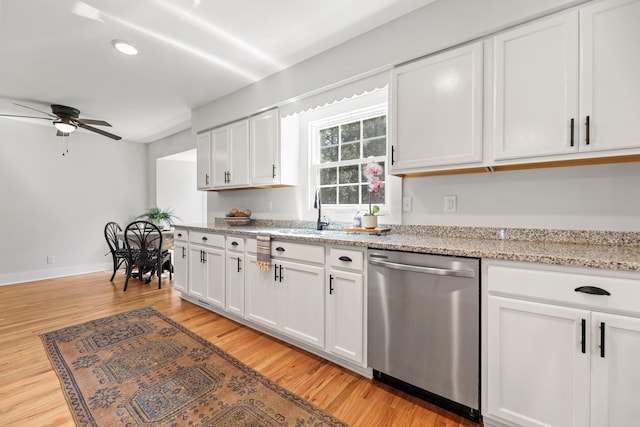 kitchen with light wood finished floors, a sink, ceiling fan, white cabinets, and dishwasher