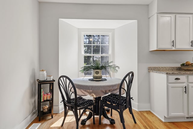 dining room with visible vents, light wood-style flooring, and baseboards