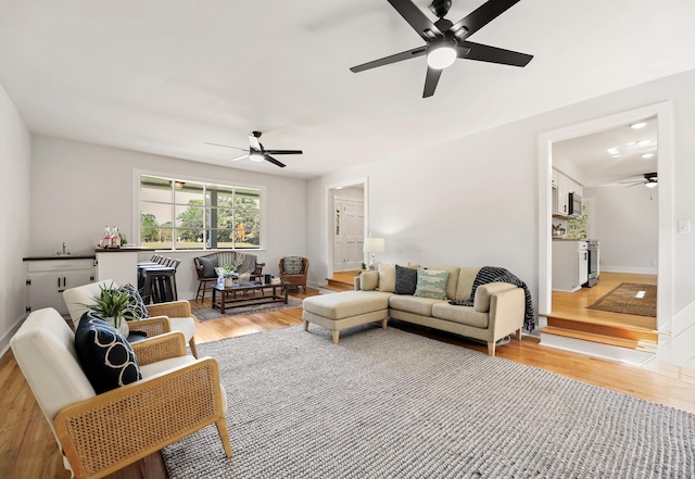 living area featuring baseboards, wood finished floors, and ceiling fan