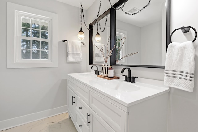 bathroom featuring a sink, baseboards, marble finish floor, and double vanity