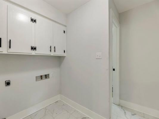 laundry area featuring baseboards, cabinet space, marble finish floor, and washer hookup