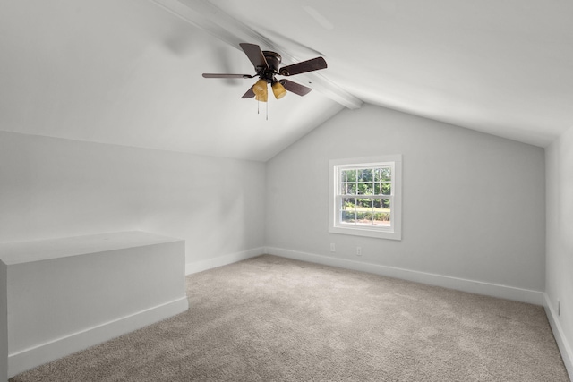 additional living space with baseboards, carpet flooring, vaulted ceiling with beams, and a ceiling fan