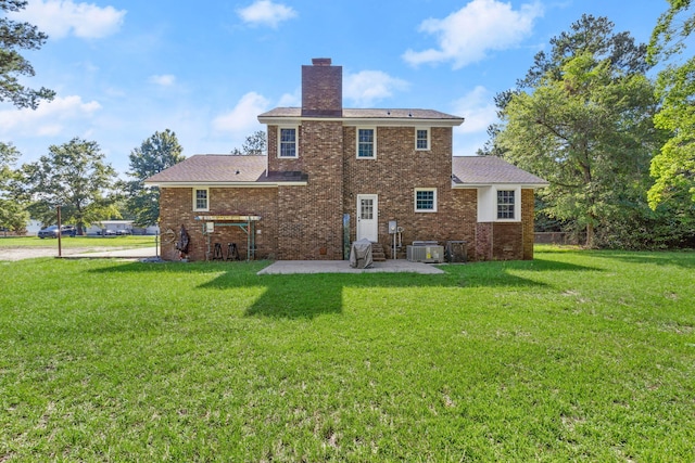 rear view of property featuring a patio area, a lawn, cooling unit, and a chimney