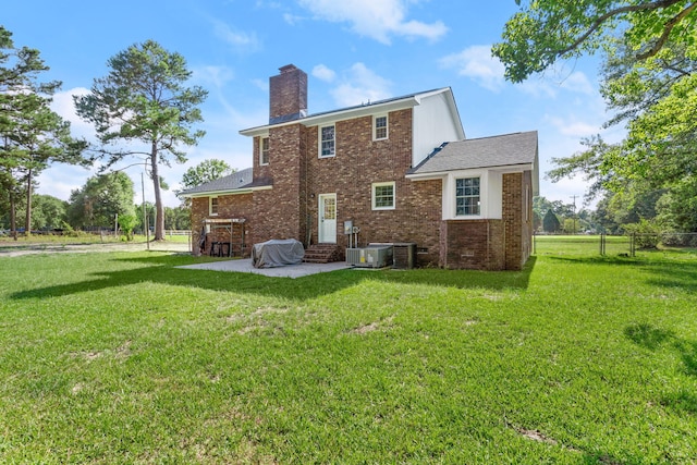 back of property with fence, brick siding, a chimney, a patio area, and a lawn