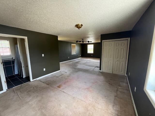unfurnished bedroom featuring carpet floors, baseboards, a closet, and a textured ceiling