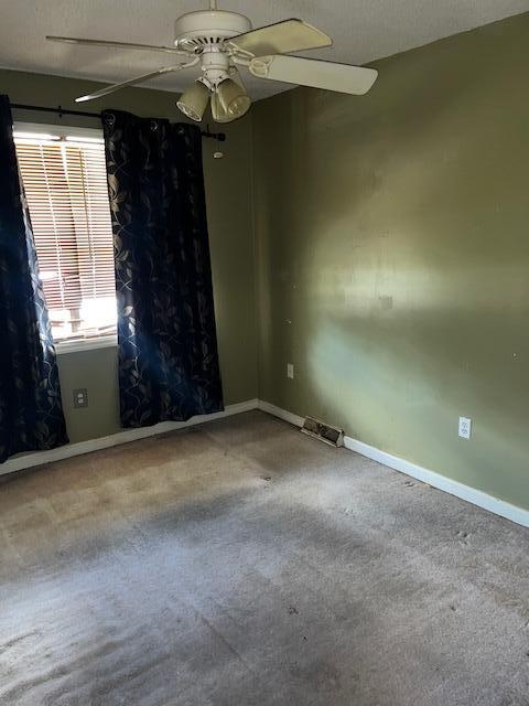 unfurnished room with ceiling fan, baseboards, and carpet
