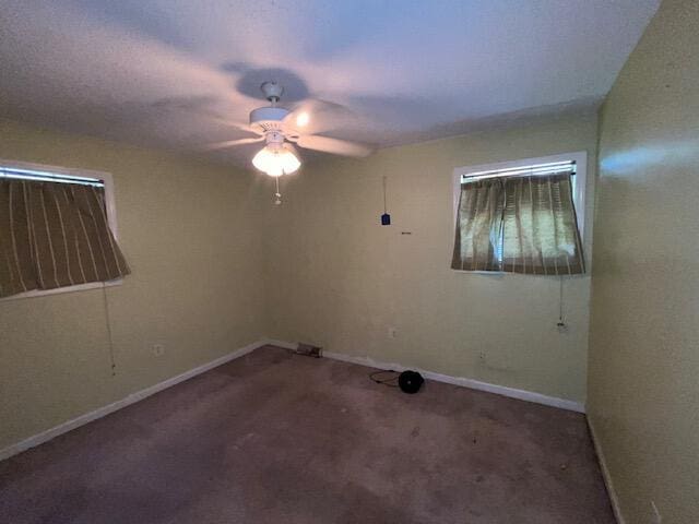 carpeted empty room with baseboards and a ceiling fan
