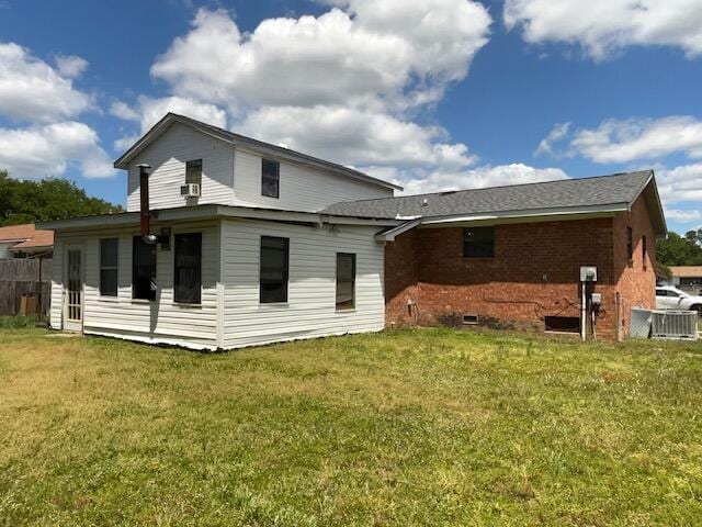 back of house with a lawn and brick siding