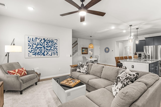 living room featuring ceiling fan, light hardwood / wood-style floors, and sink