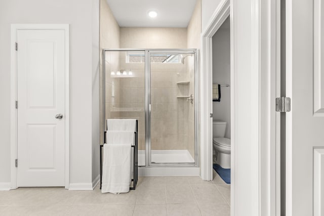 bathroom featuring tile patterned floors, toilet, and an enclosed shower