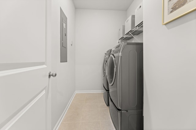 clothes washing area featuring light tile patterned floors and washer and dryer