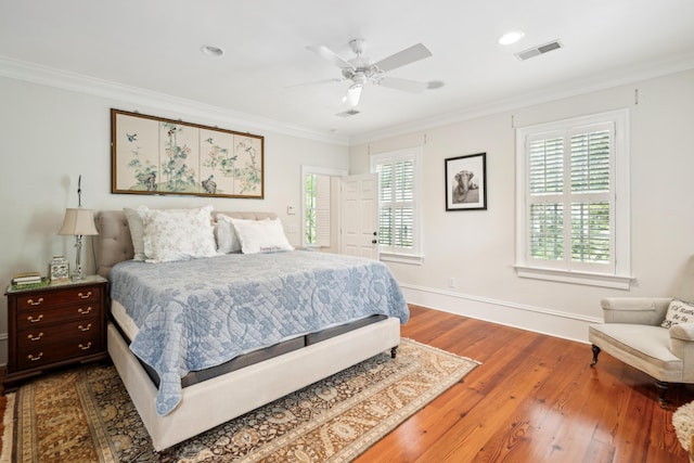 bedroom featuring dark wood finished floors, baseboards, visible vents, and crown molding