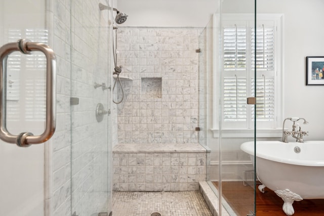 full bathroom featuring a freestanding bath and a shower stall