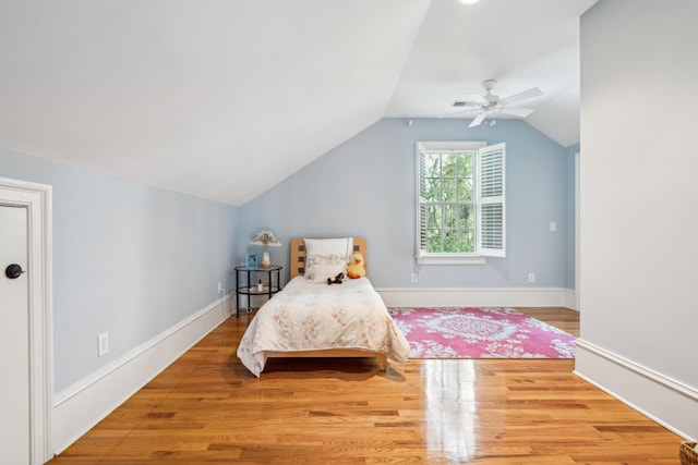 bedroom featuring baseboards, lofted ceiling, and wood finished floors