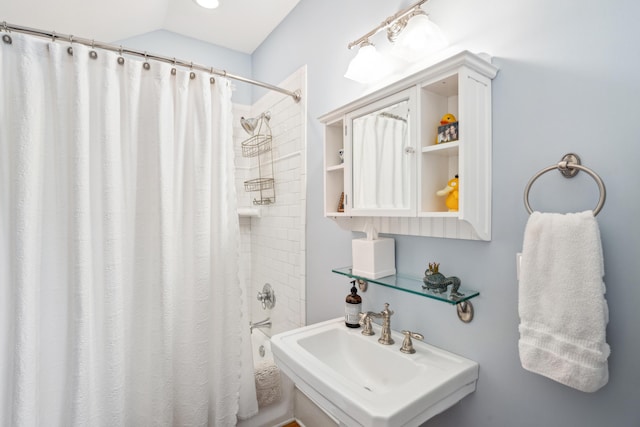 full bathroom featuring shower / bath combo with shower curtain, a sink, and lofted ceiling
