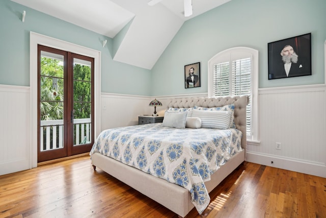 bedroom with multiple windows, access to exterior, and wainscoting