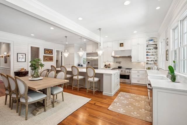 dining area featuring crown molding, light wood-style floors, and recessed lighting