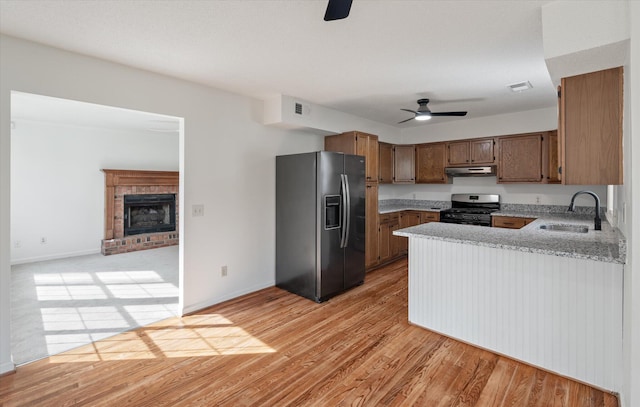 kitchen with sink, light hardwood / wood-style flooring, appliances with stainless steel finishes, kitchen peninsula, and ceiling fan